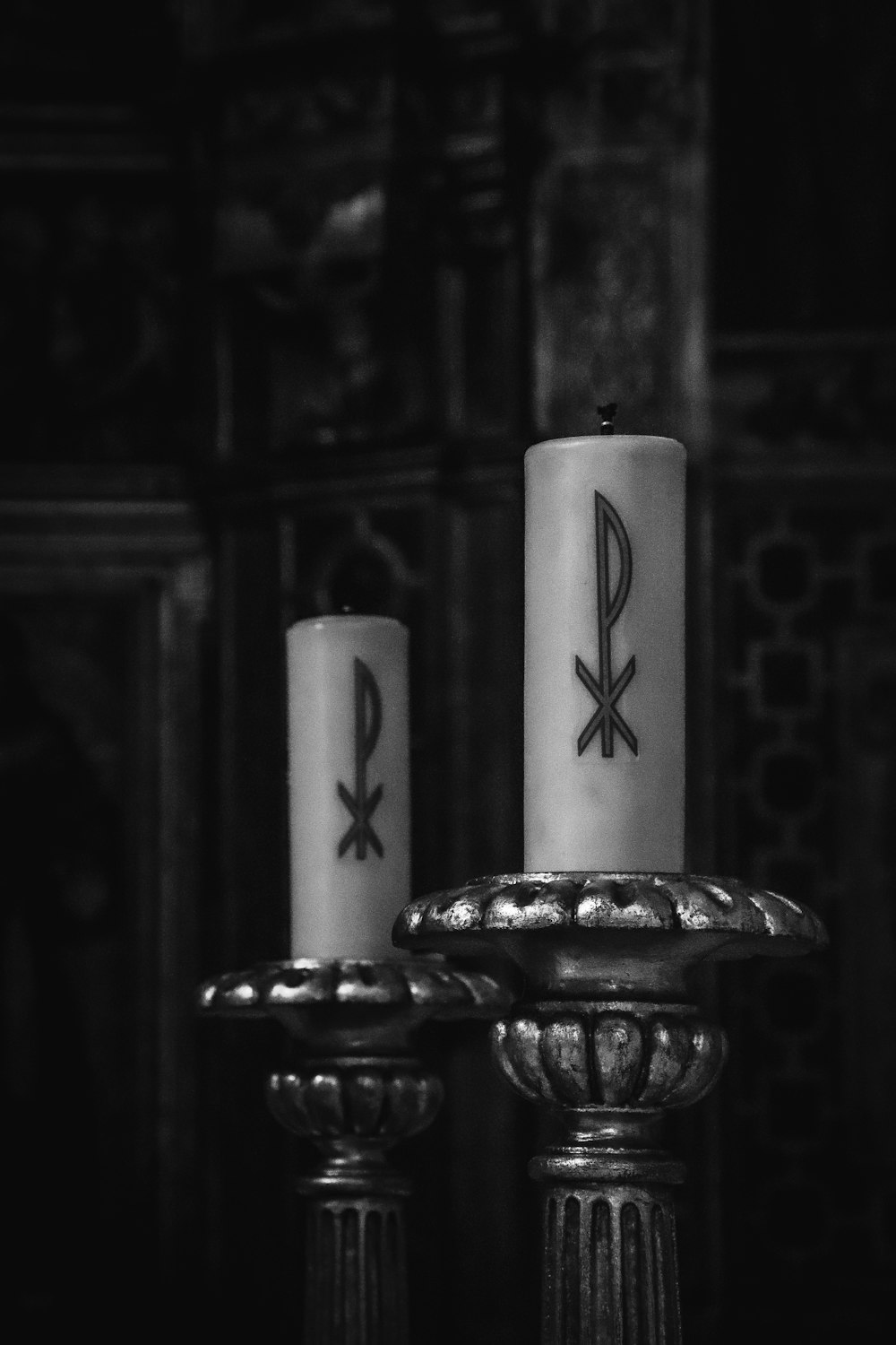 two candles sitting on top of a metal stand