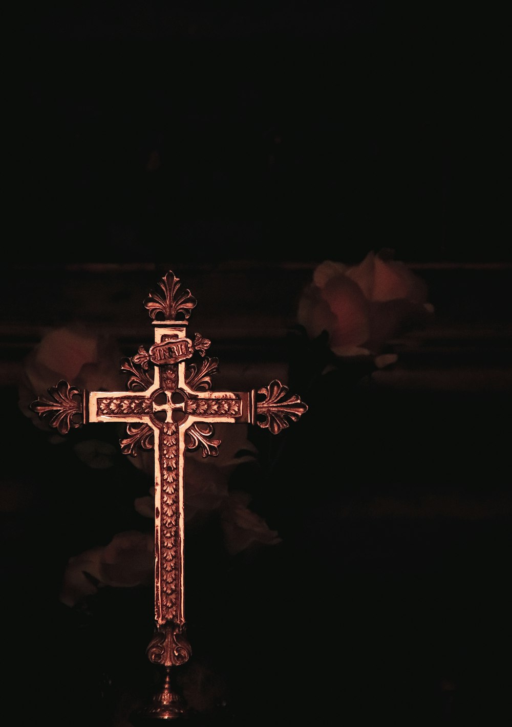 a cross is lit up in the dark