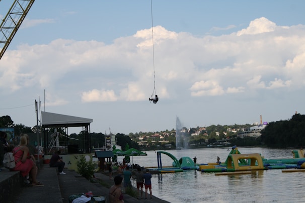 Adventurer mid-air during a bungee jump with the iconic Laxman Jhula bridge in view