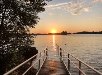 A serene view of Davis Lake surrounded by the condo buildings with the sun setting behind the trees.