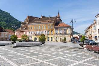 a town square with benches and buildings in the background