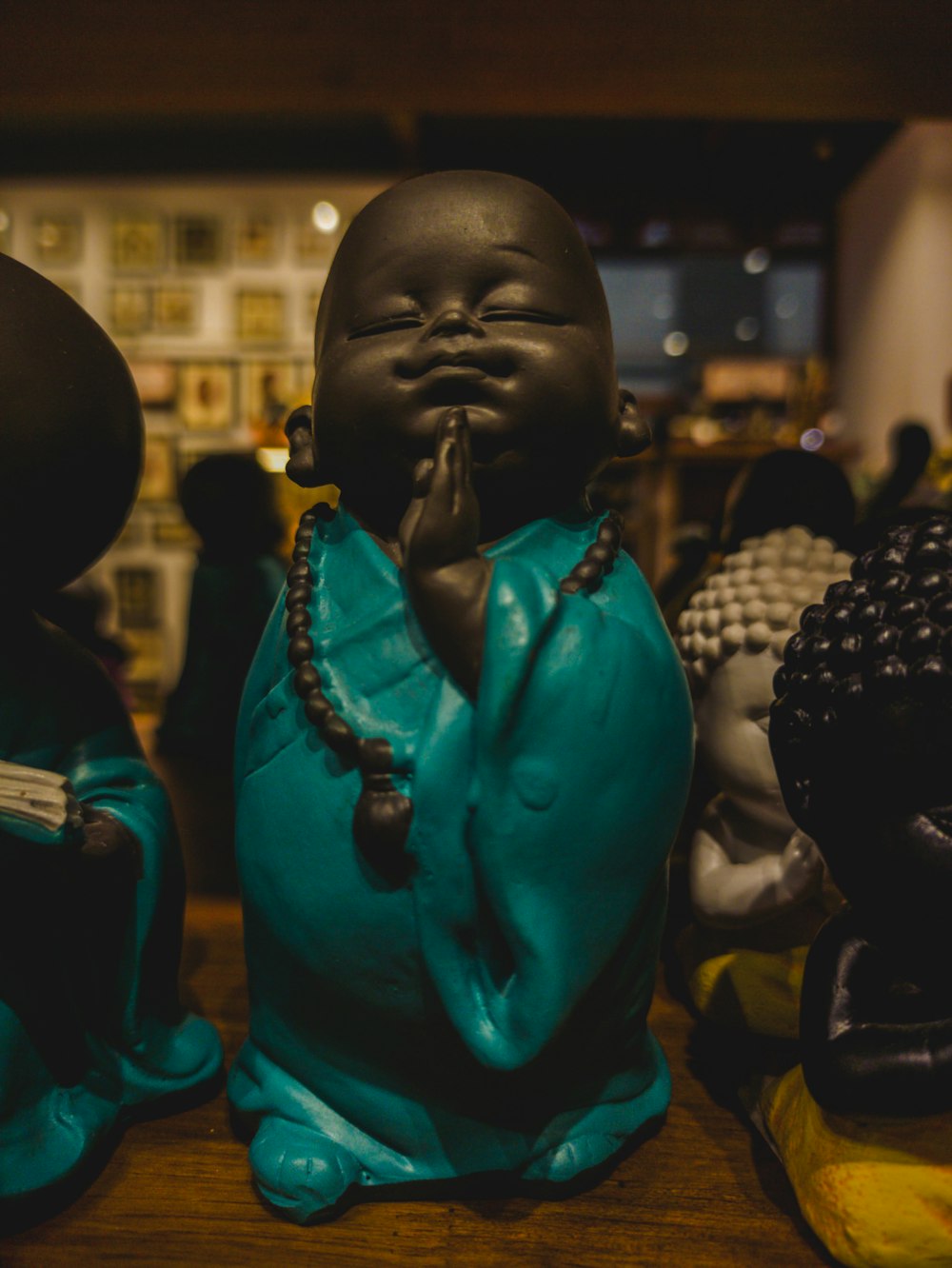 a group of buddha statues sitting on top of a wooden table