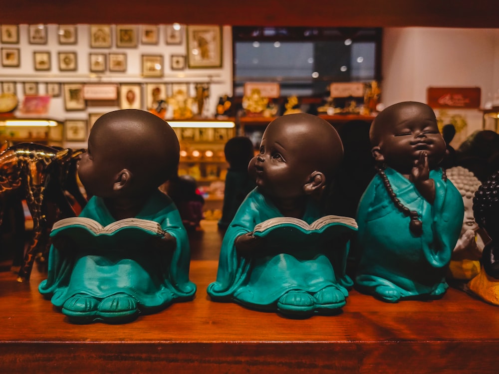 a group of three small statues of people