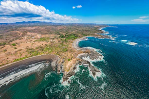 an aerial view of the coastline of a tropical island