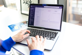 a person typing on a laptop computer on a desk