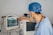 a man in scrubs and a stethoscope looking at a monitor