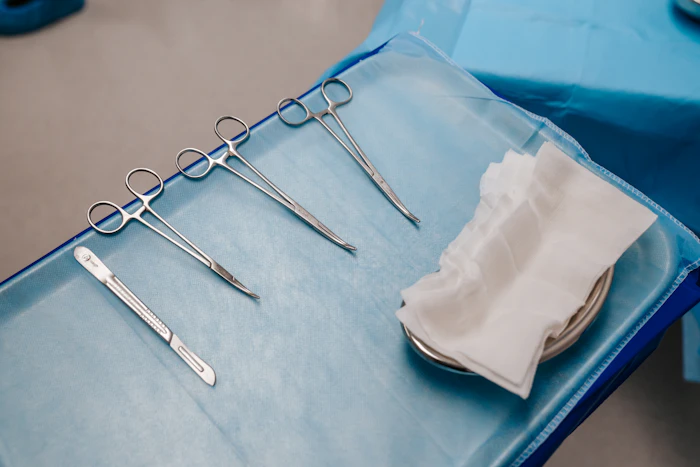 A tray of stainless steel surgical instruments