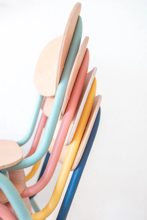 Colorful wooden kids' chairs arranged in a playful setting.