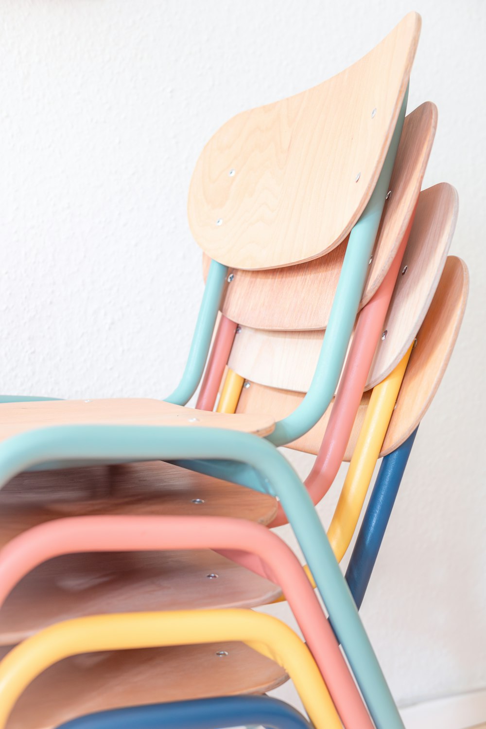 uma pilha de cadeiras coloridas sentadas uma ao lado da outra