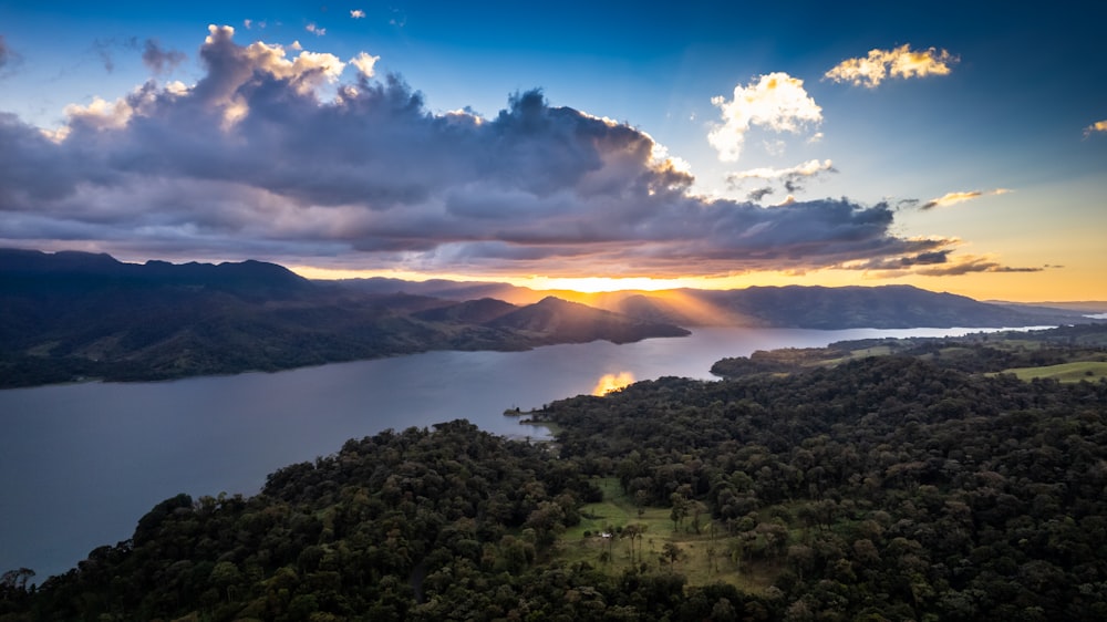 Le soleil se couche sur un lac entouré de montagnes