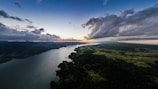 A panoramic view of Tocantins’ natural landscape with green forests and a river at sunset.