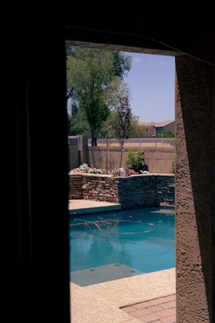 A backyard scene showcasing a freshly constructed pool with surrounding landscaping.