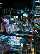 A vibrant cityscape at dusk featuring bright digital billboards and OOH media installations.