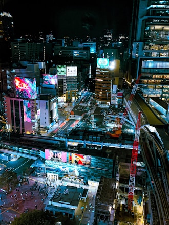 A vibrant cityscape showing various digital billboards and screens displaying dynamic advertisements linked by glowing network lines.