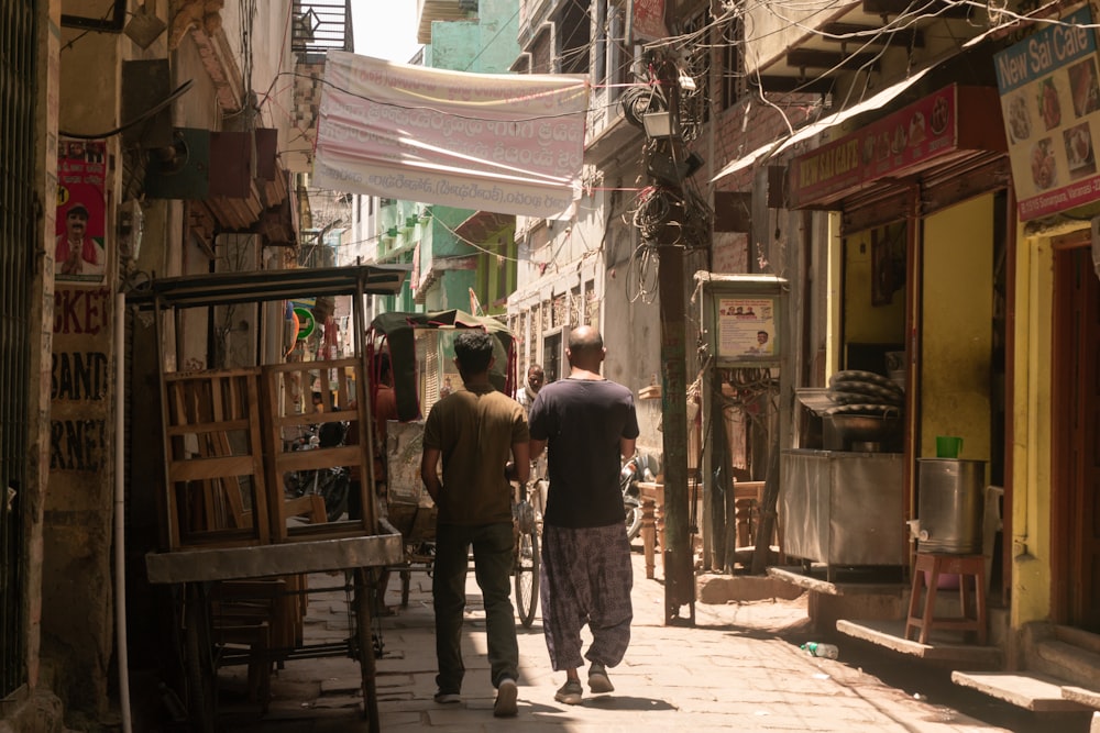 a couple of men walking down a street next to a building