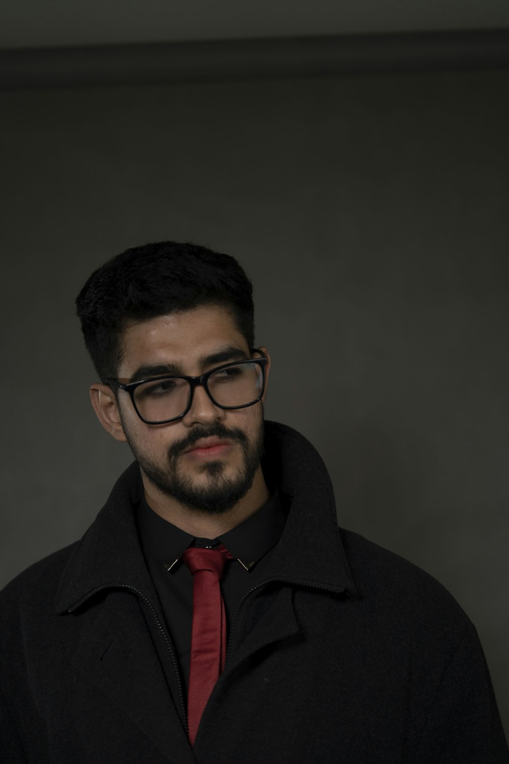 a man wearing glasses and a red tie