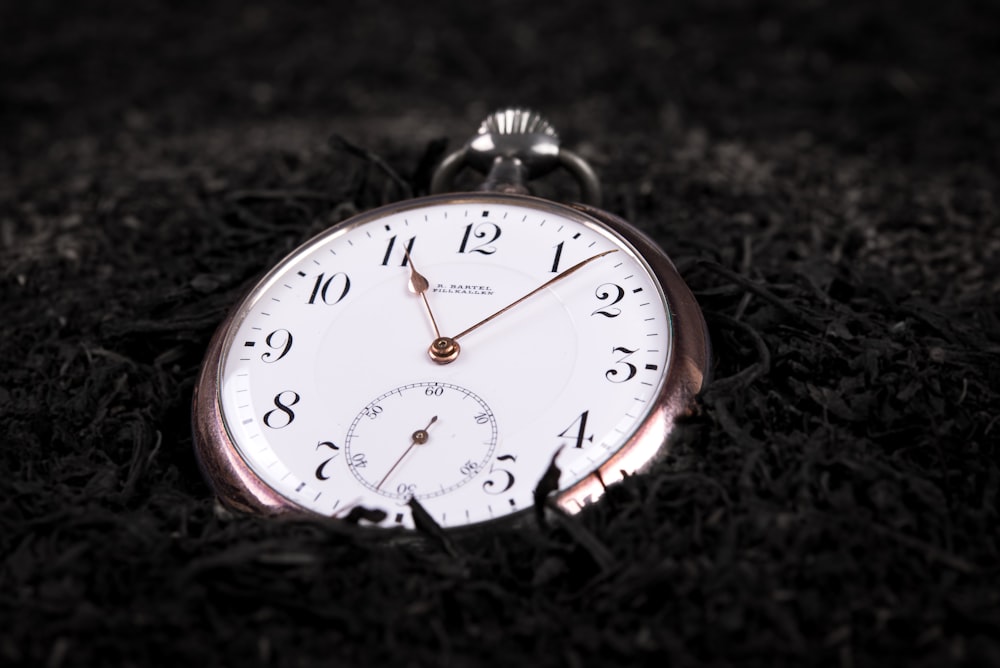 a close up of a pocket watch laying on the ground