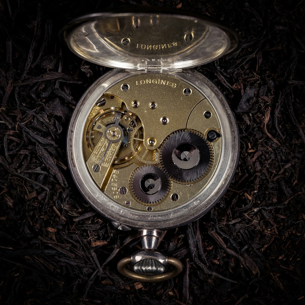 um close up de um relógio de bolso no chão