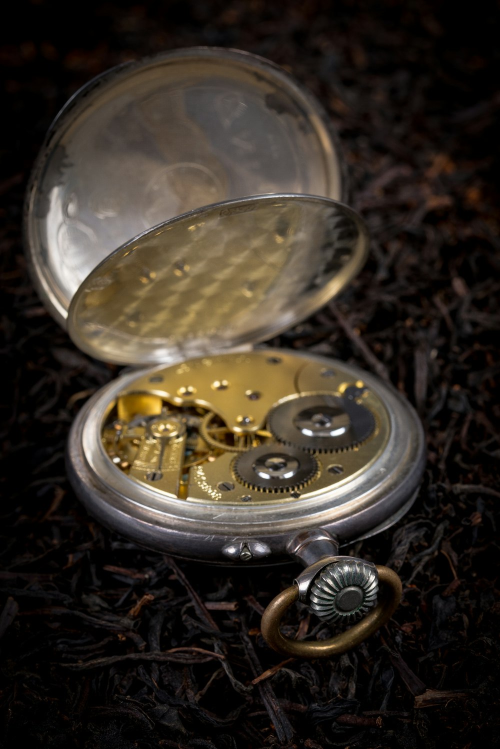 Un reloj de bolsillo abierto sentado en el suelo
