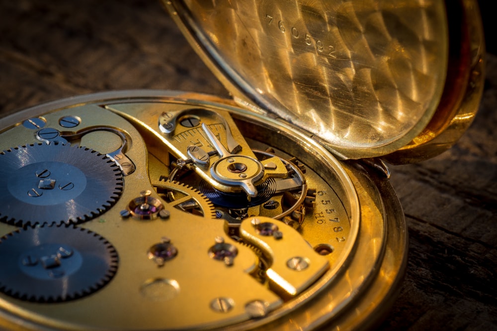 a close up of a gold pocket watch