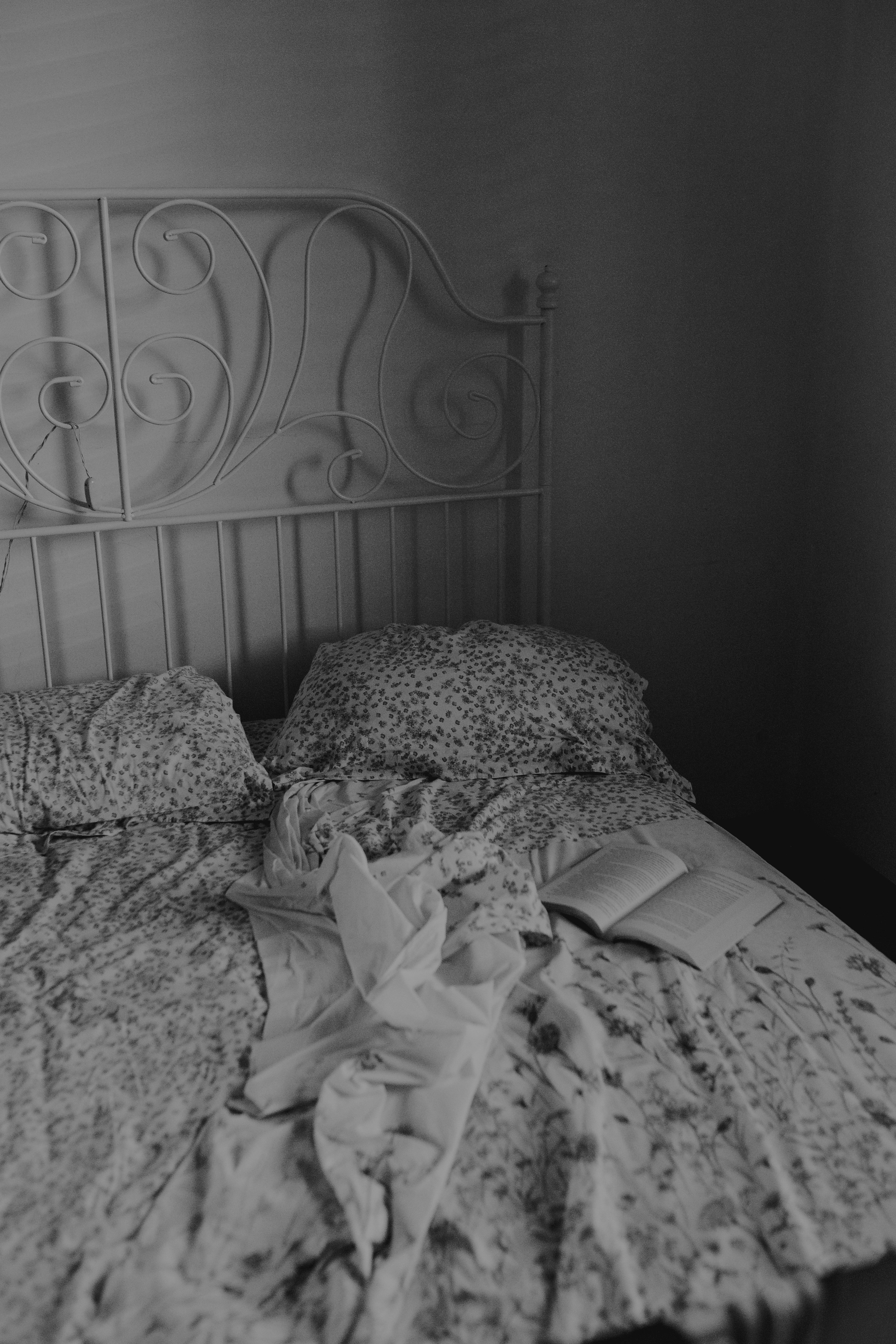 a messy bed with a book on top of it