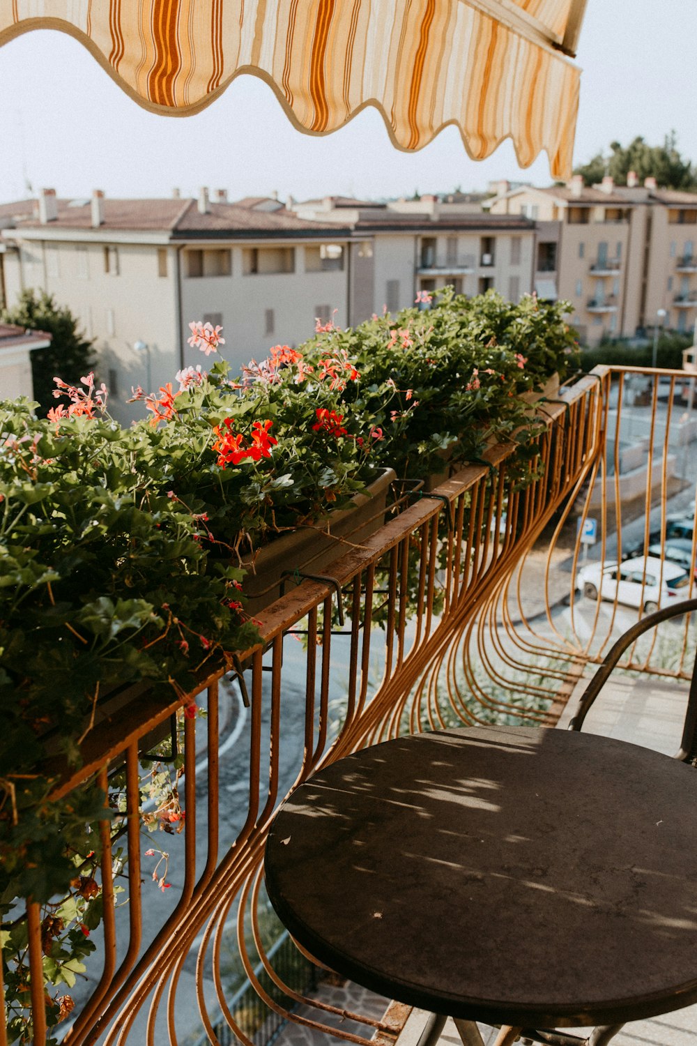 a balcony with a table and chairs and flowers