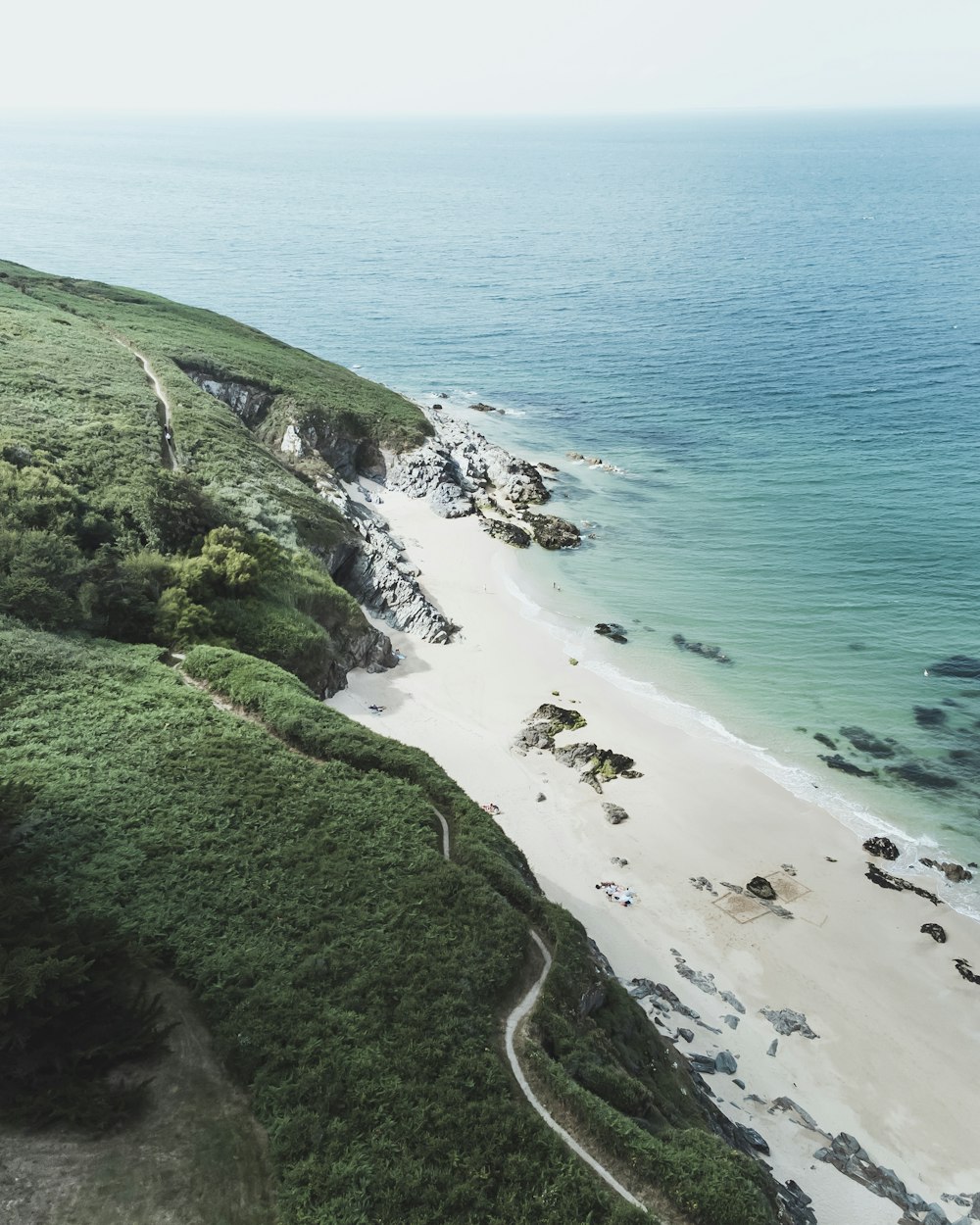 uma vista aérea de uma praia de areia e oceano