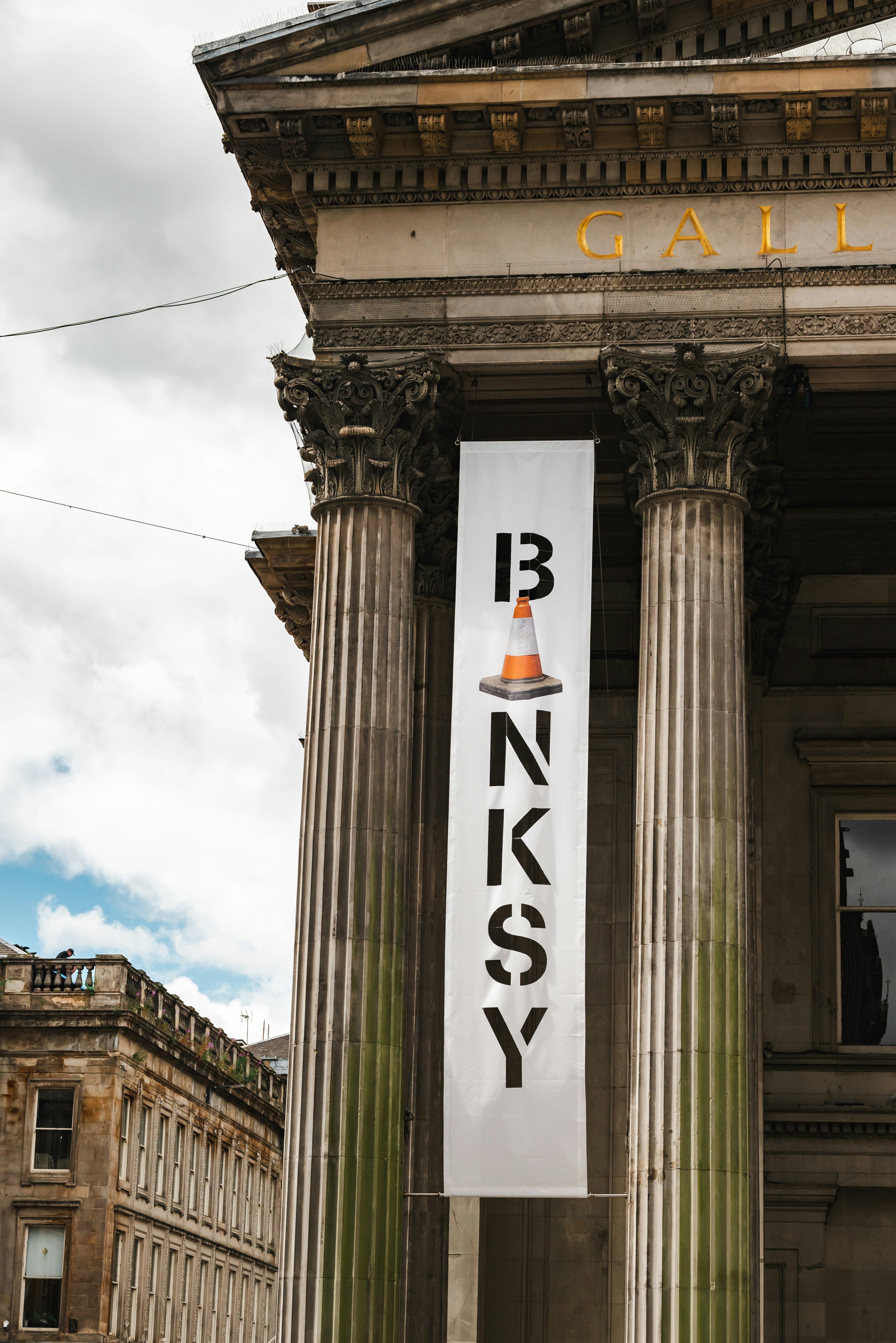 ein Schild, das an der Seite eines hohen Gebäudes hängt