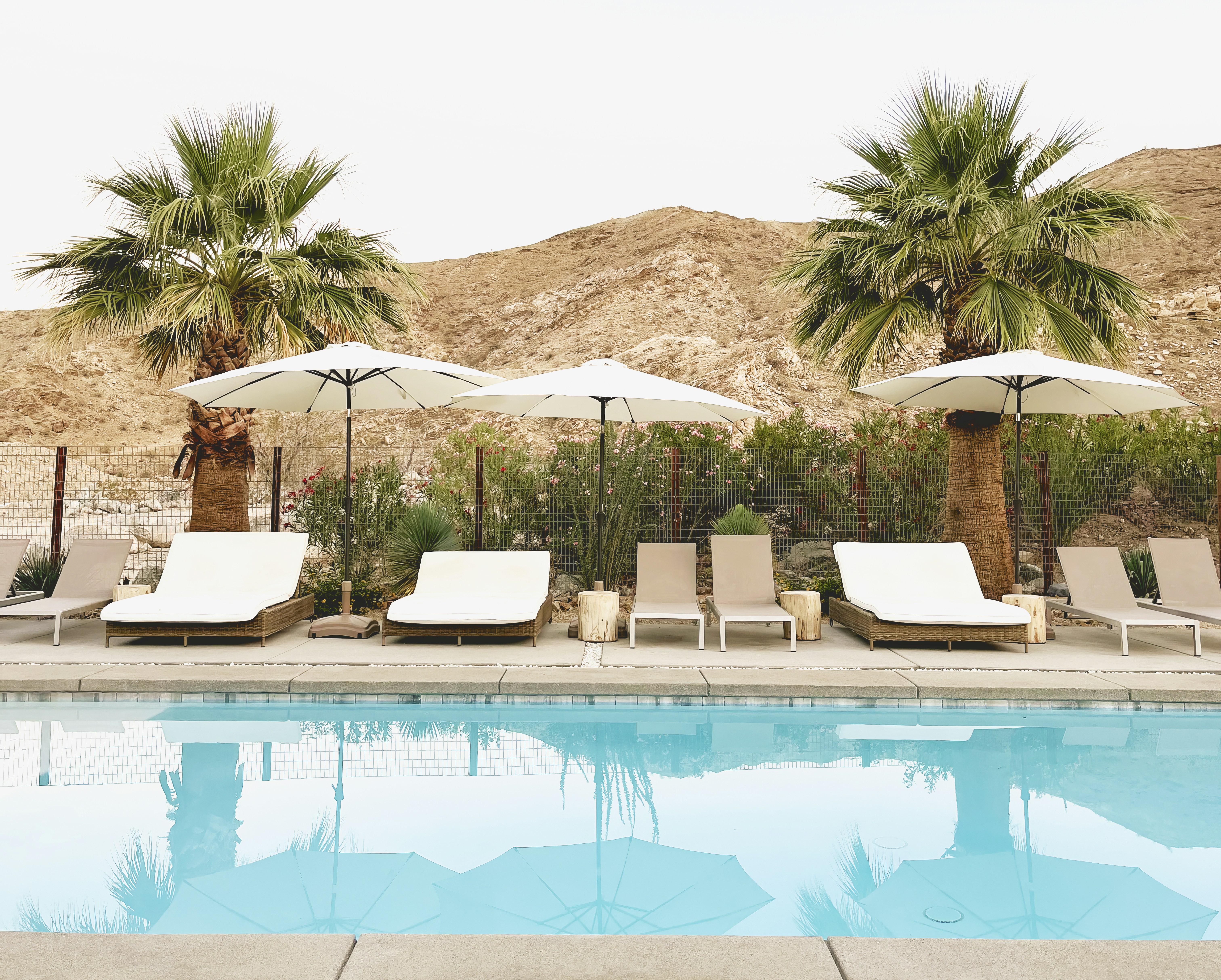 a couple of lawn chairs sitting next to a swimming pool