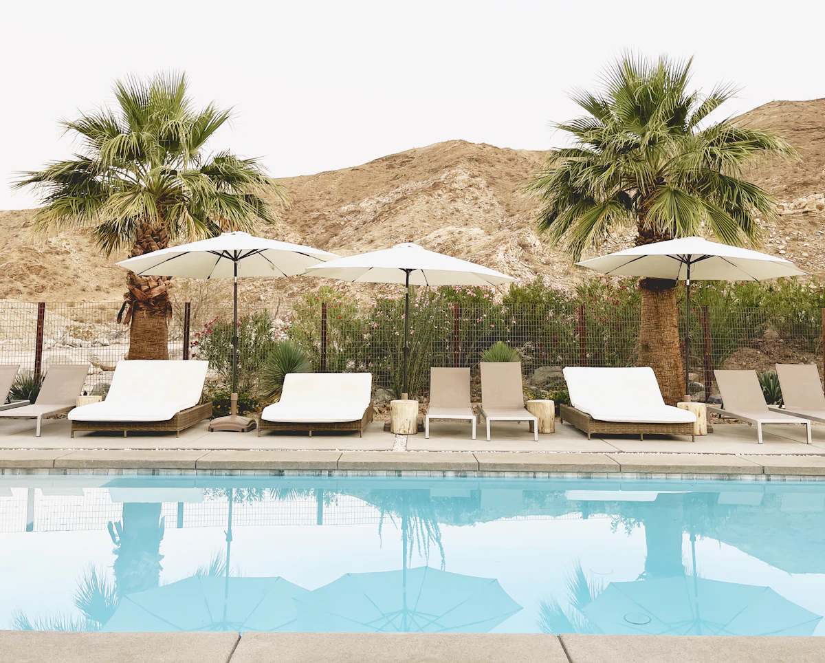 Quiet poolside with lounge chairs at a desert home ready to be left for the season