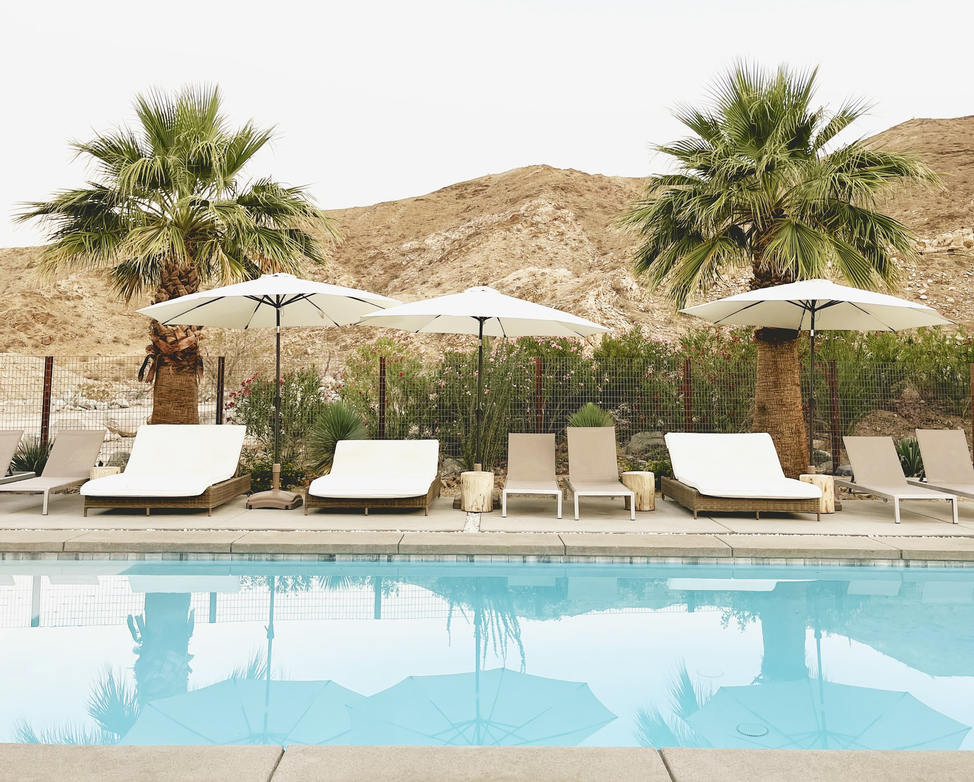 a couple of lawn chairs sitting next to a swimming pool