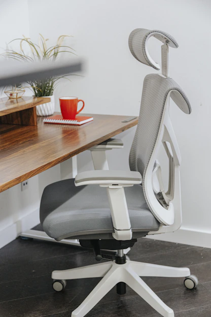 A modern ergonomic office chair in a bright, airy workspace with natural light.