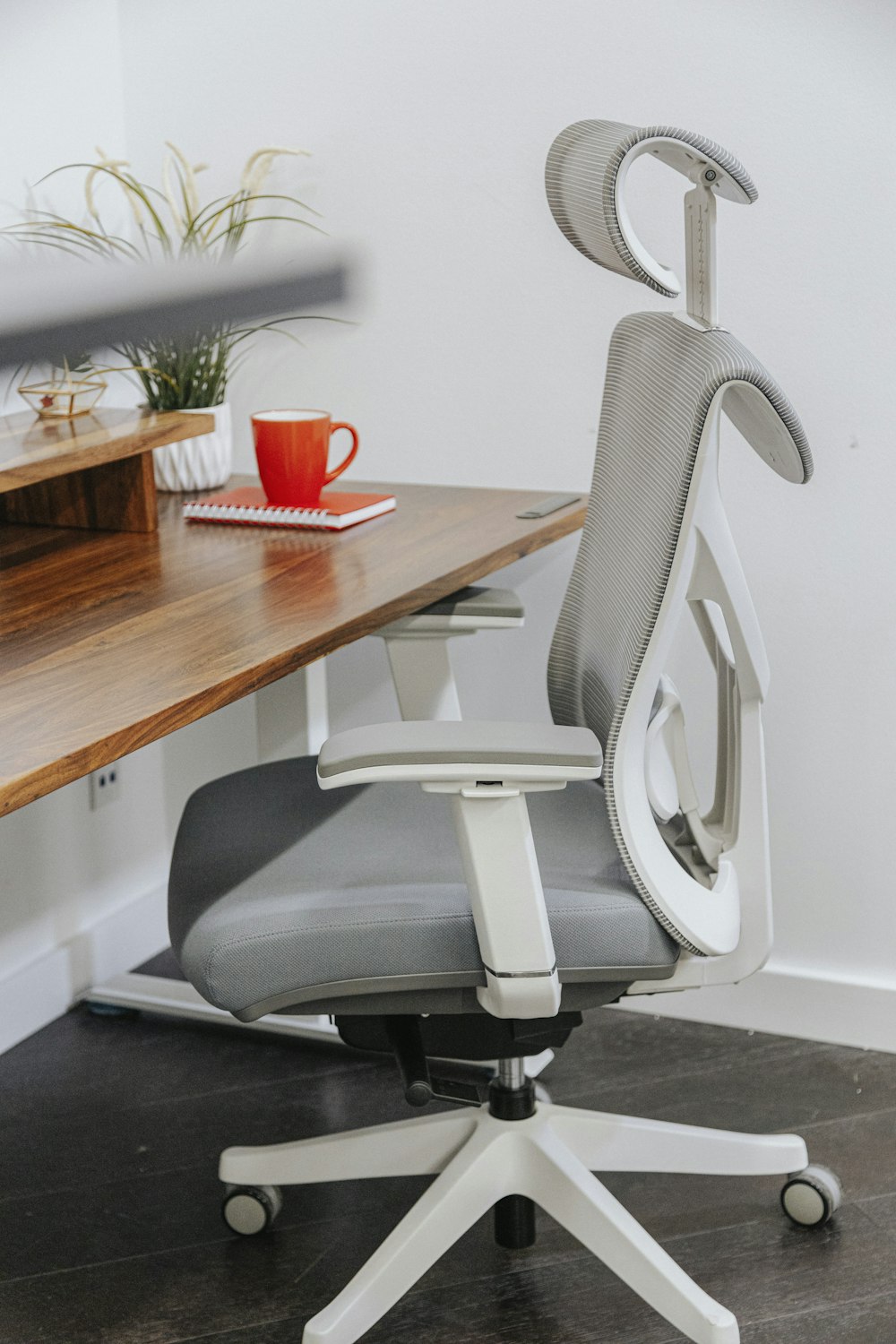una silla de oficina sentada encima de un escritorio de madera