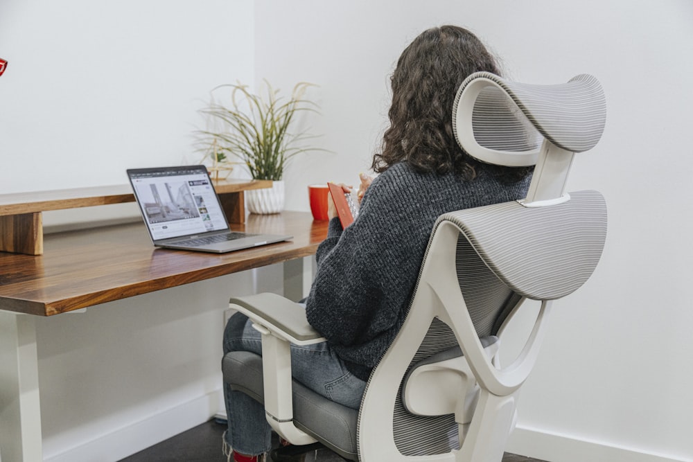 a woman sitting at a desk with a laptop