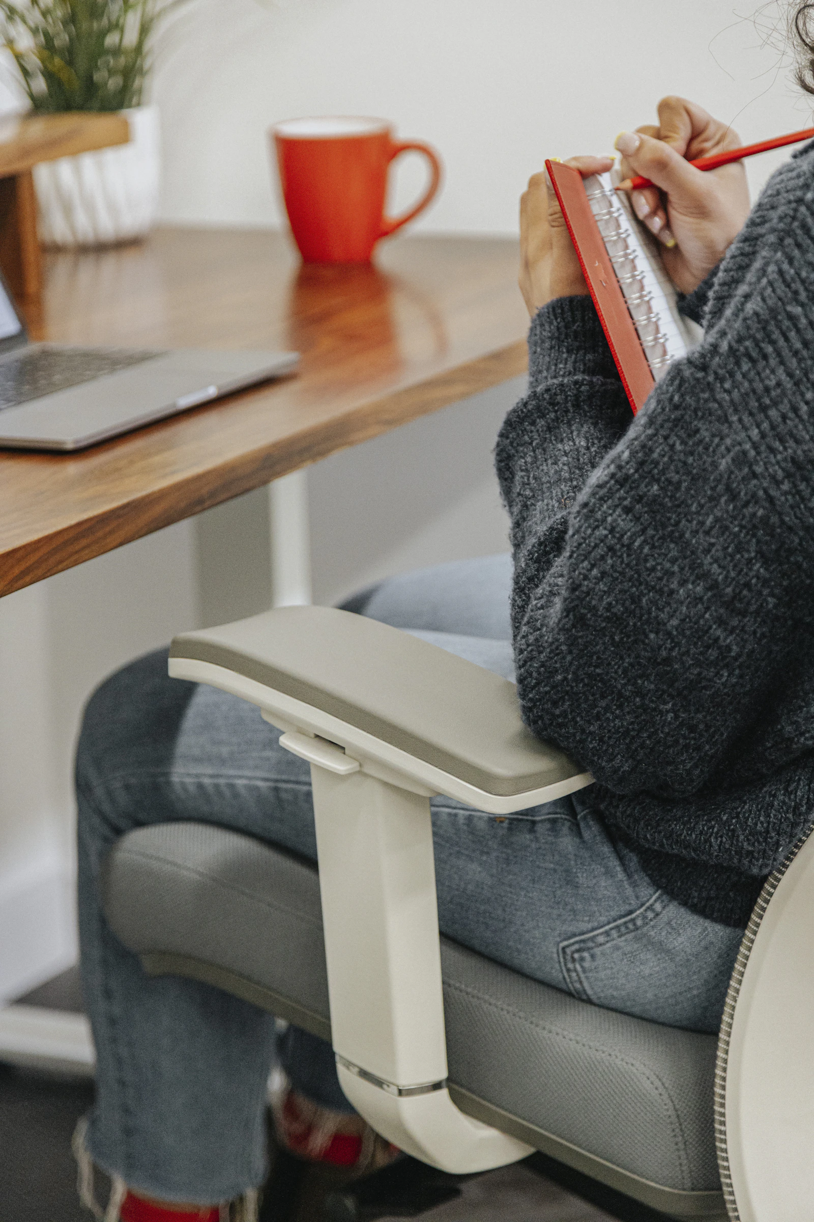 Personne assise à un bureau, jambes sous la table
