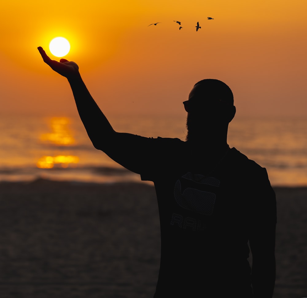 a man standing on top of a beach holding a frisbee