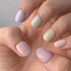 Close-up of perfectly manicured hands showcasing a minimalist gel-x nail design in pastel tones.