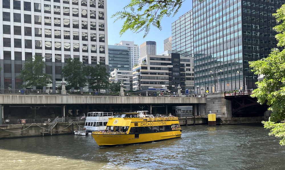 Un bote amarillo que viaja río abajo junto a edificios altos