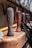 Wooden handles with a weathered texture lined up on a wooden surface, accompanied by coiled black ropes and hardware components in a blurred background.