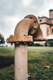 a rusted fire hydrant in front of a large building