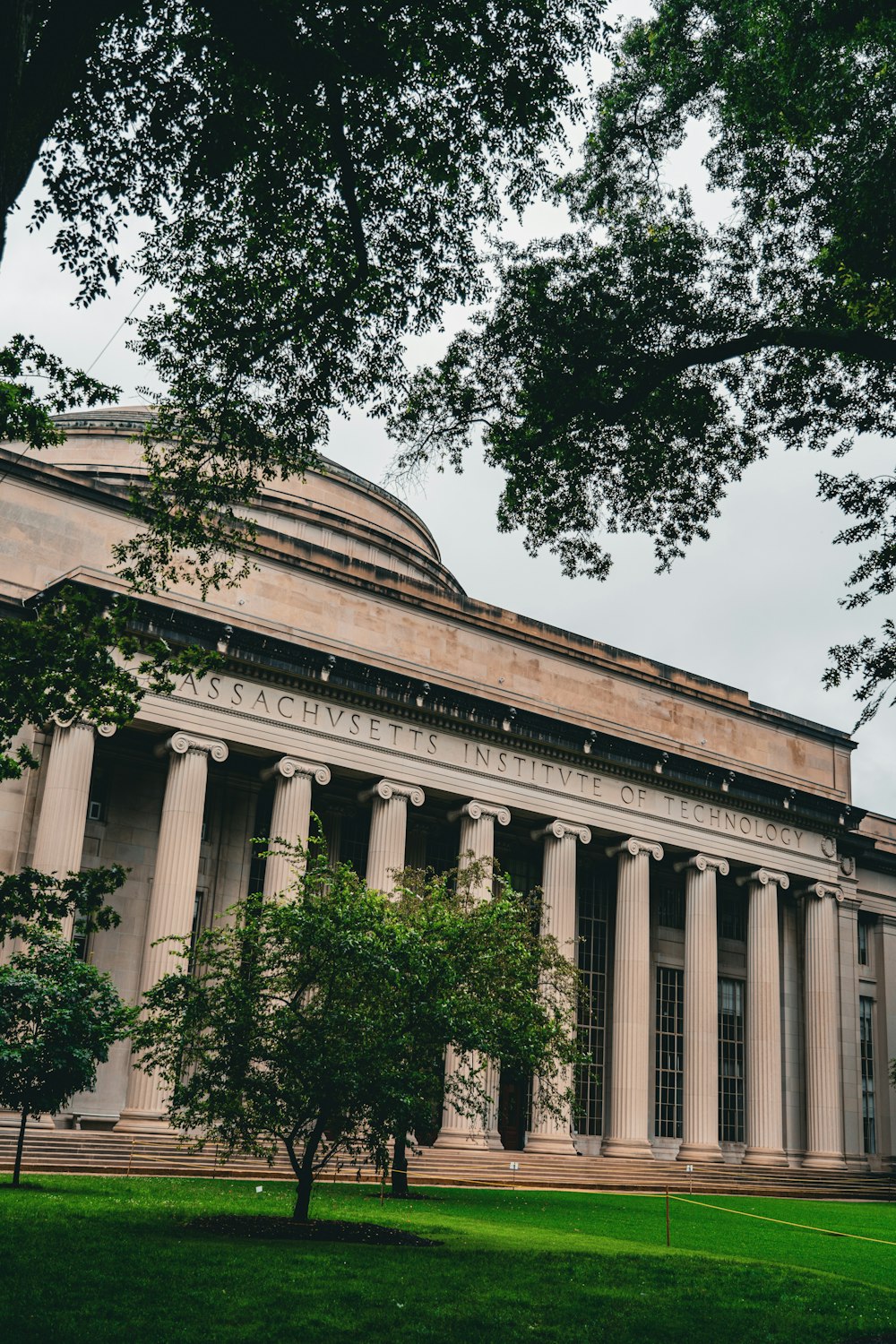 a large building with columns and trees in front of it