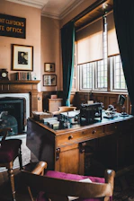 Elegant office interior with dark green accents and a vintage architectural blueprint on the desk