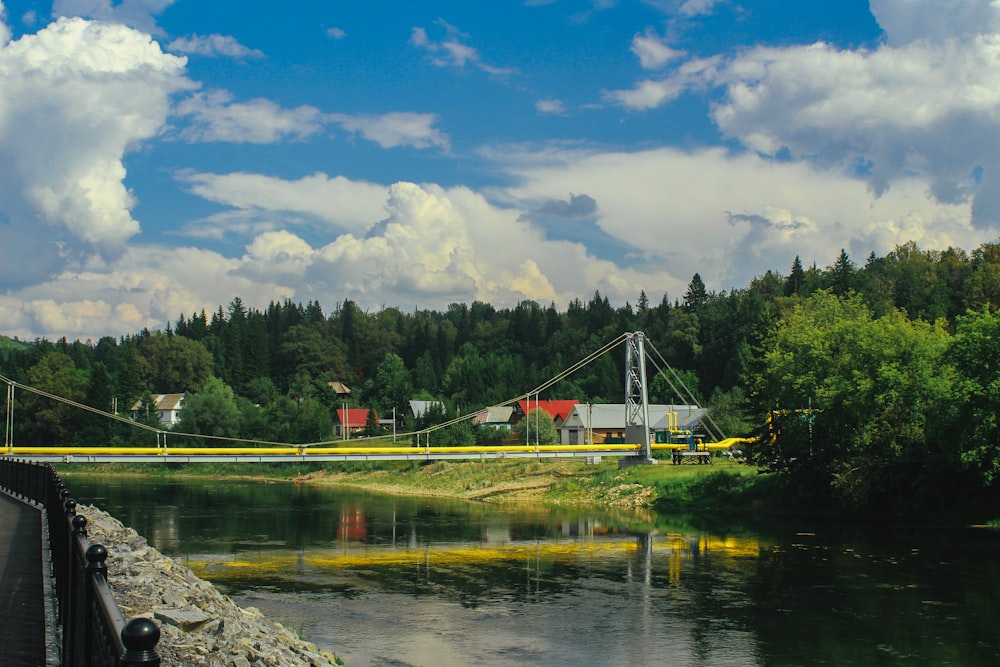 a bridge over a river next to a forest