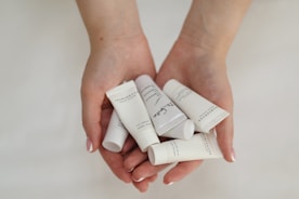 a person holding five tubes of toothpaste in their hands