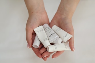 a person holding five tubes of toothpaste in their hands