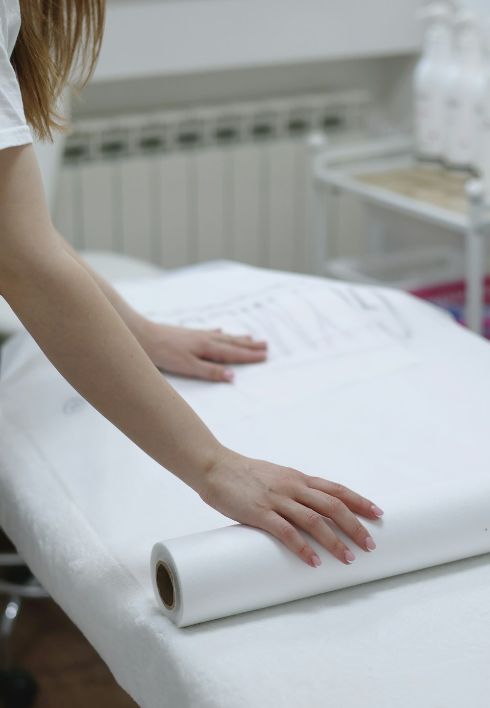 a woman rolling up a mattress on top of a table