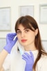 a woman in a white shirt and purple gloves