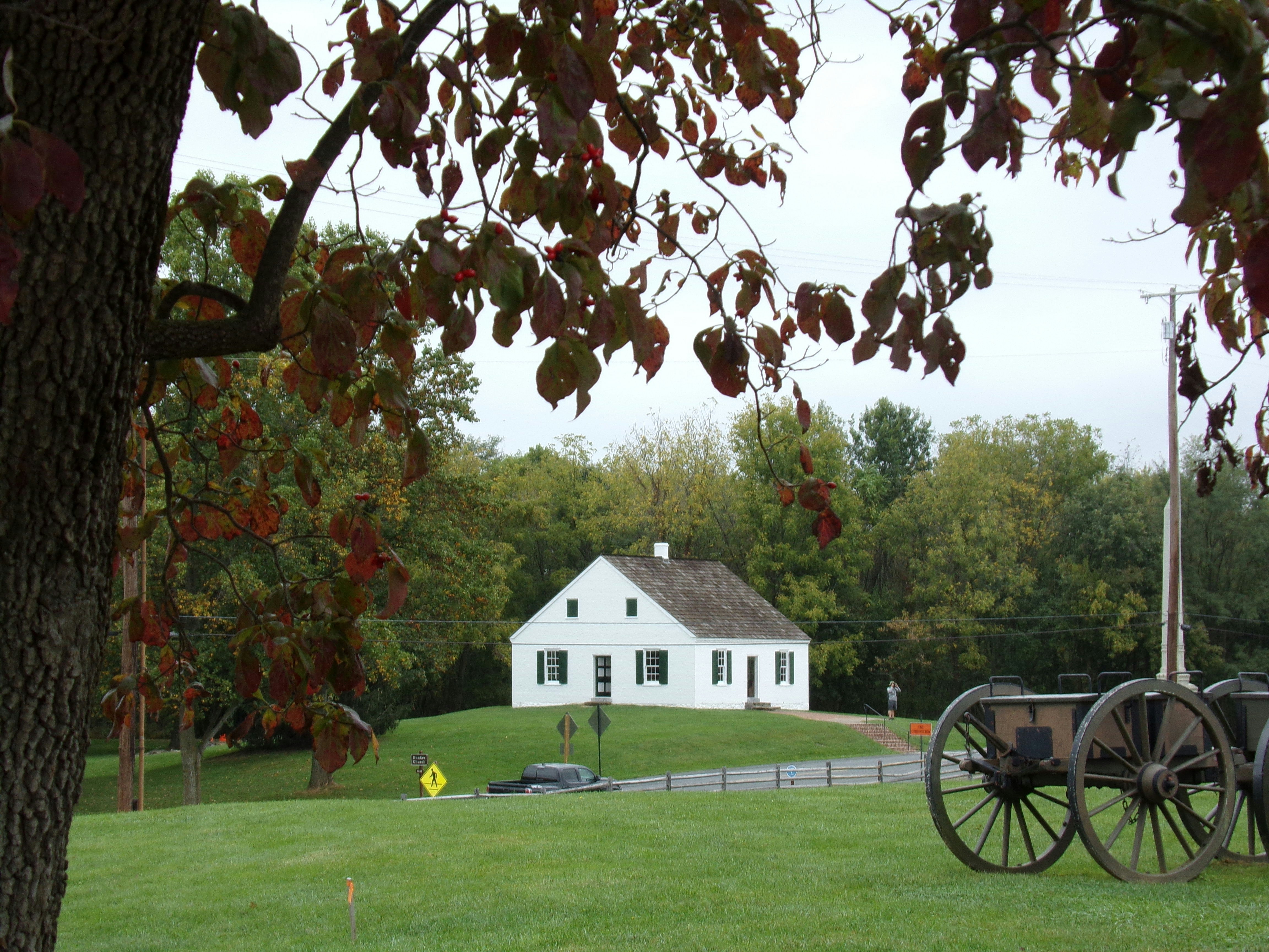 a white house sitting on top of a lush green field