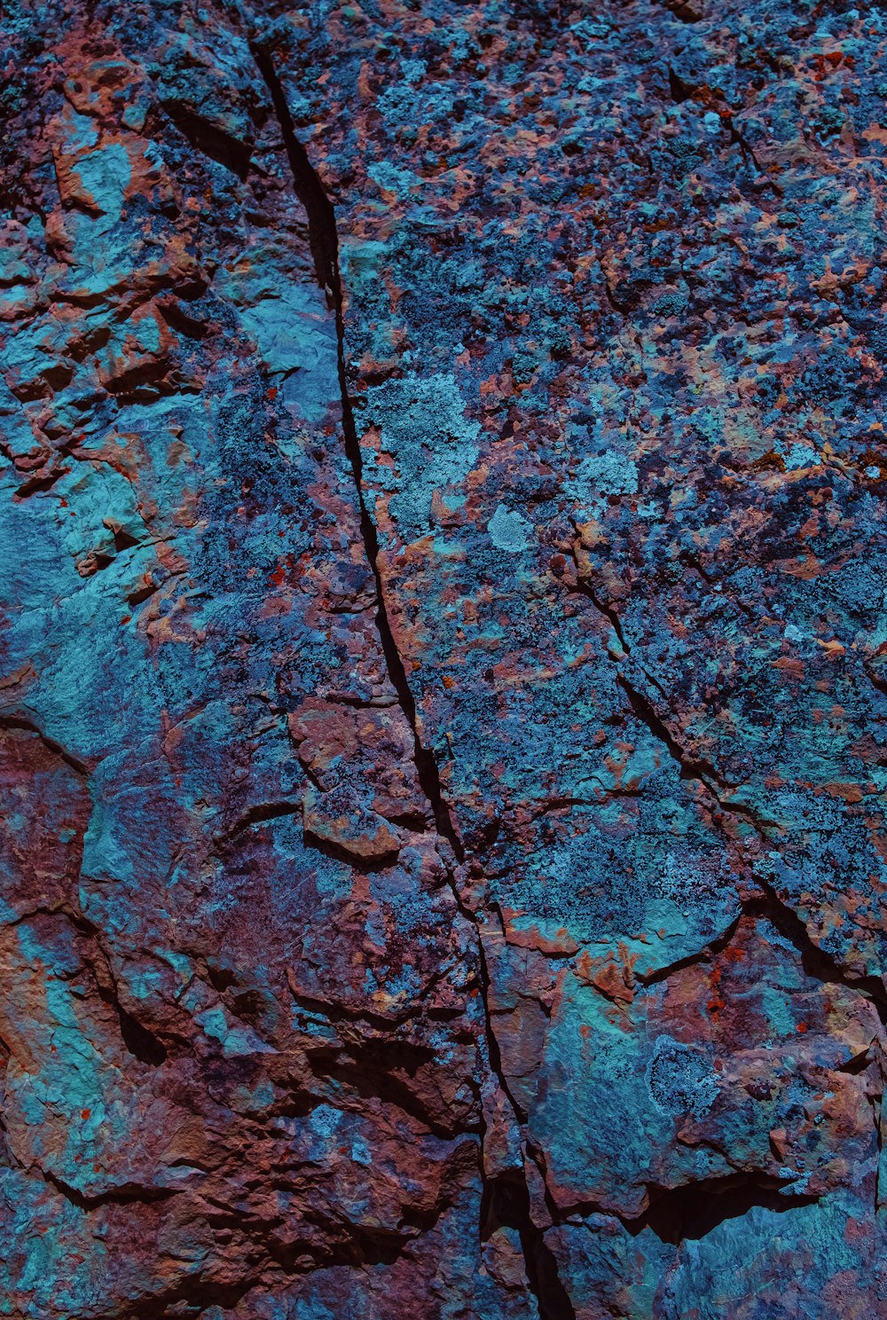 a close up of a rock with a blue and red substance on it