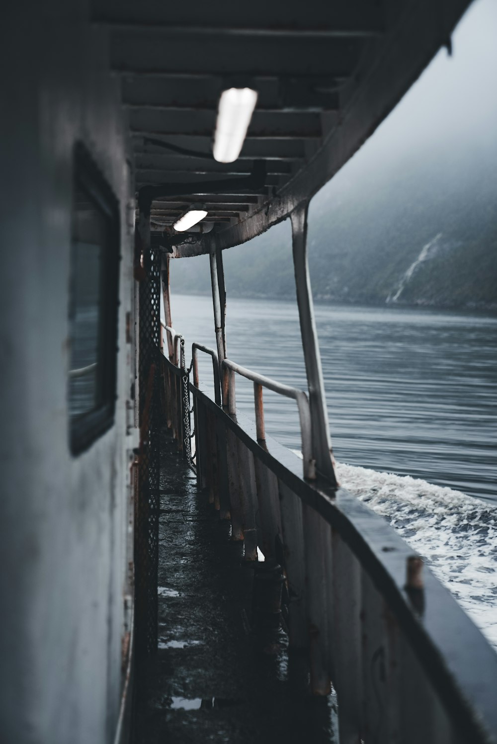 a boat traveling on a body of water on a foggy day